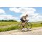 man biking uphill on an a/1, clouds and grass in background